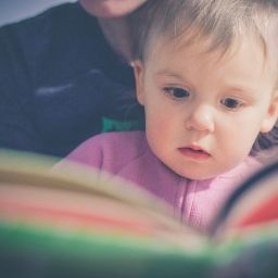 Parent reading book to young child