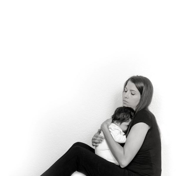 Woman sitting on floor holding dark haired baby